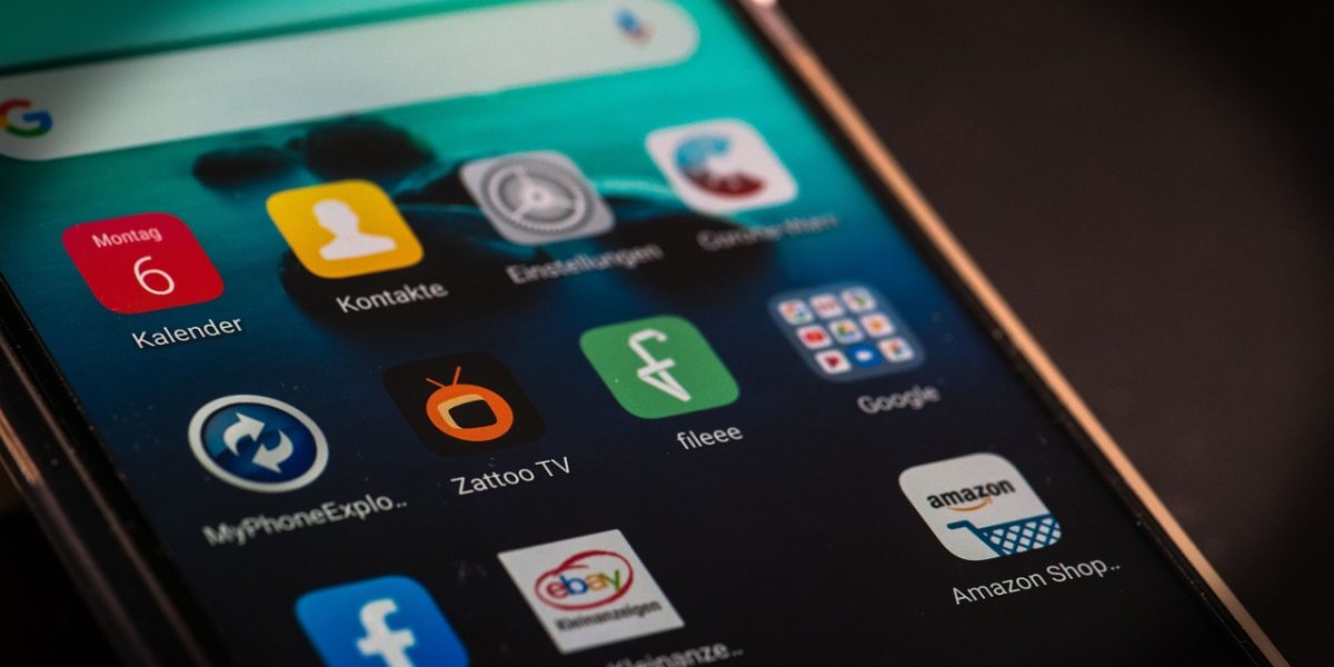 斗球体育直播 App 主视觉：深蓝紫色的手机屏幕里，一场足球赛的实时比分与赛程列表静静排开，夜色中的客厅只有屏幕的光